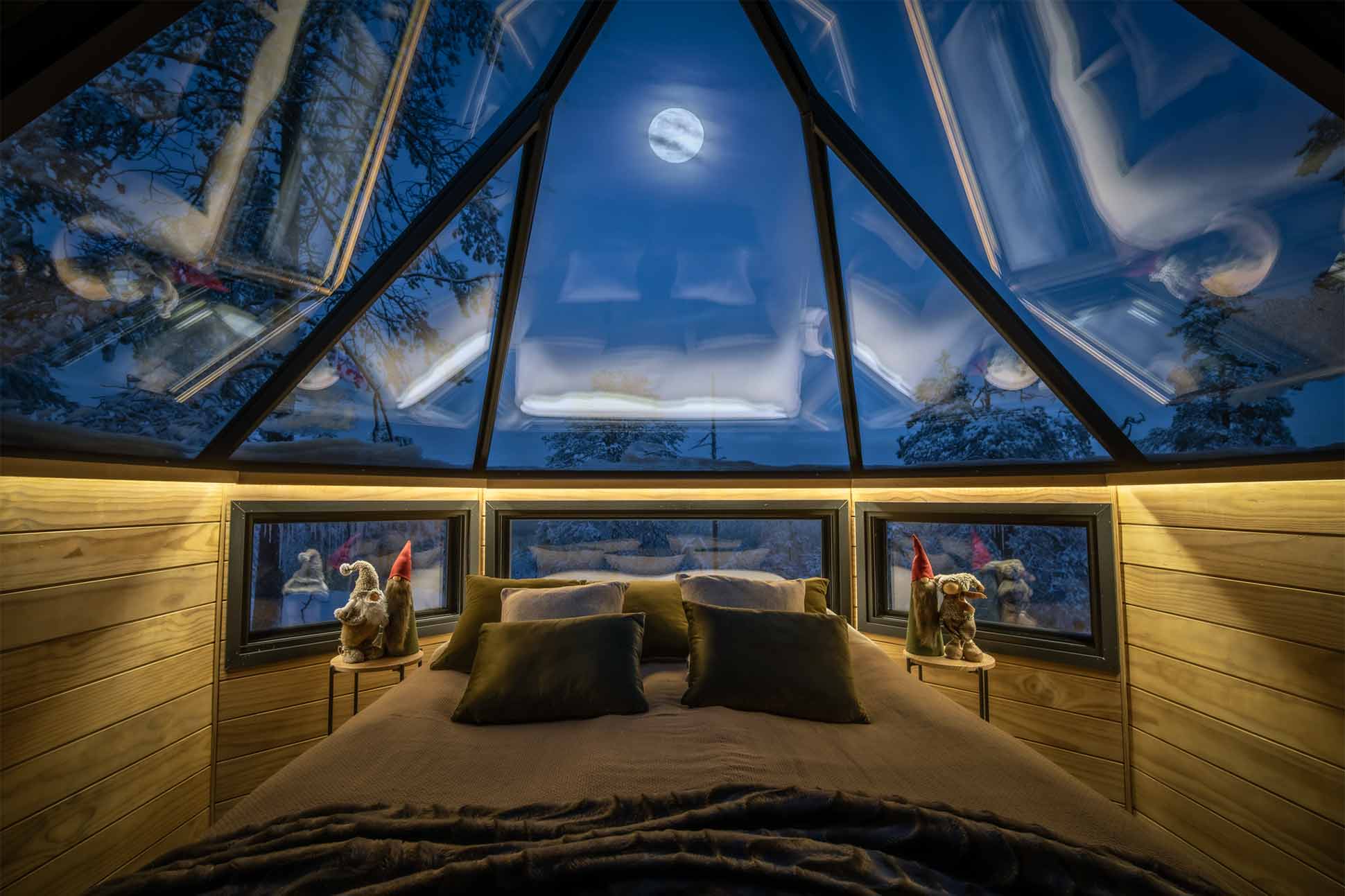 Lodge windows and firelight against snow at Octola Private Wilderness near Rovaniemi