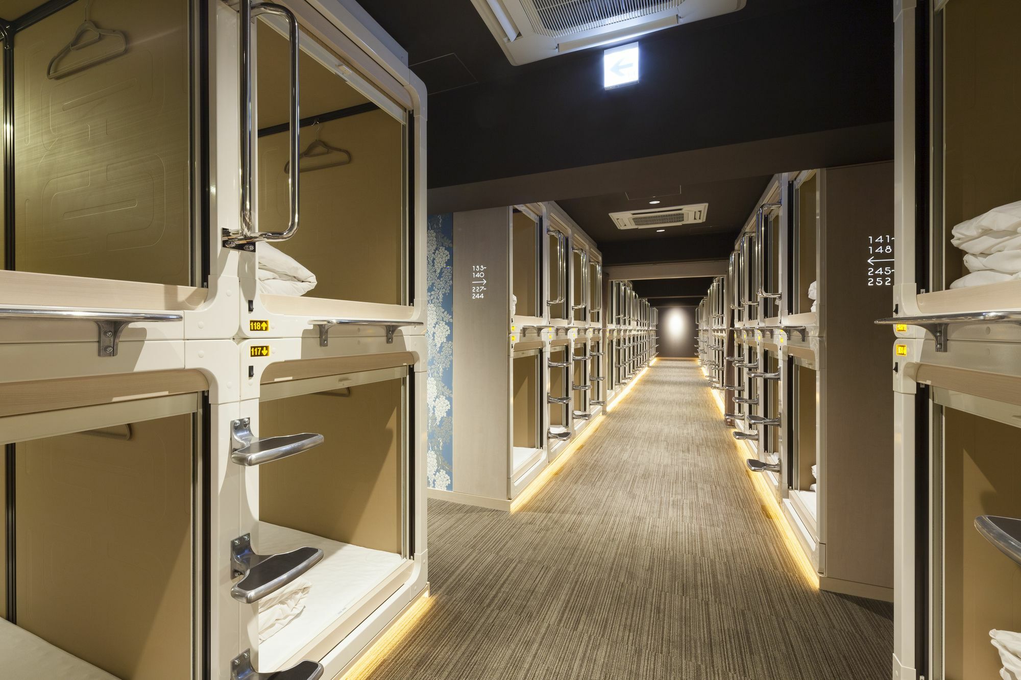 A dimmed capsule corridor at Bay Hotel Ginza above the shopfronts of Tokyo