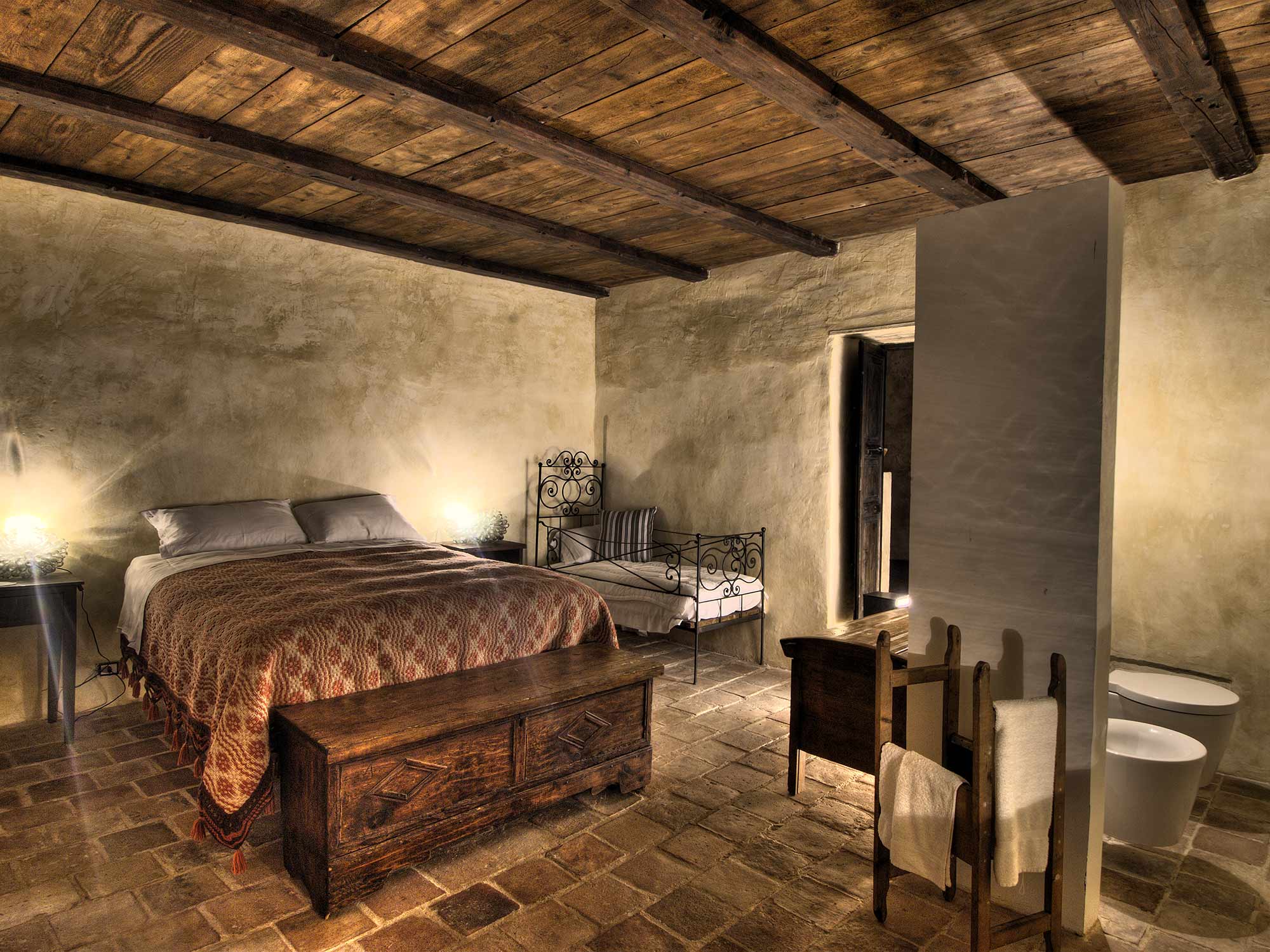 Candlelight on bare plaster and a stone floor at Sextantio Albergo Diffuso in Abruzzo