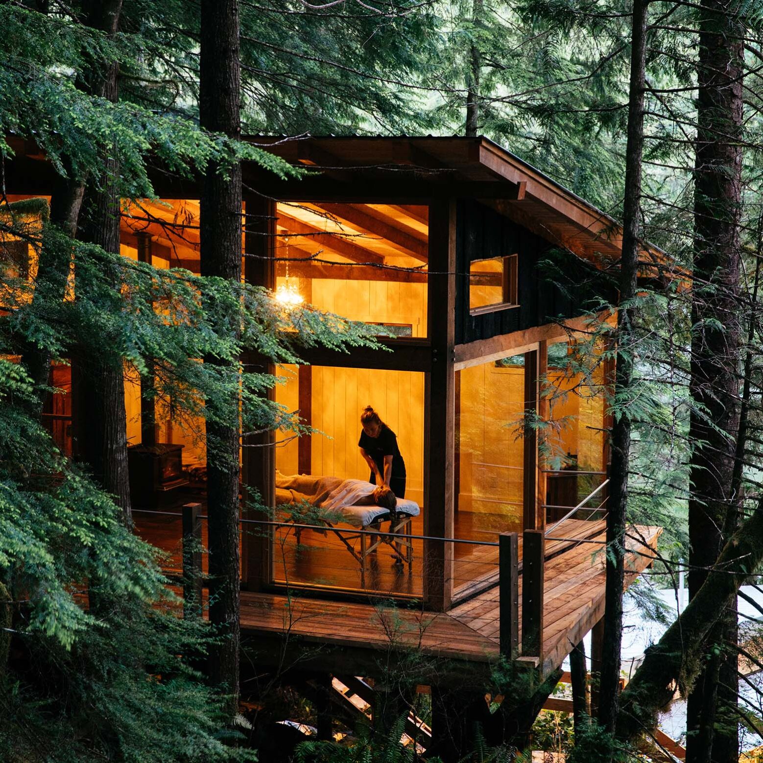 Fire bowl on the dock and lit cabin windows at Nimmo Bay Resort in British Columbia